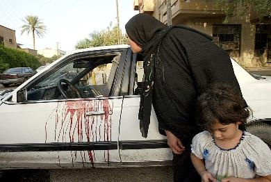 امرأة عراقية تشاهد دماء ملطخة بإحدى السيارات أمس