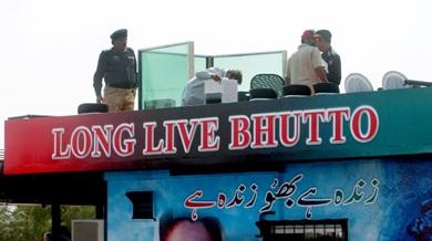 رجال الامن الباكستانيون يؤمنون الشاحنة قبل وصول بوتو..وآثار الرصاص تبدو على القفص الزجاجي المصفح في الشاحنة بعد الحادثة