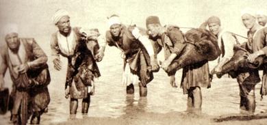 رجال ينقلون المياه بالقرب من الصهاريج في بداية القرن العشرين