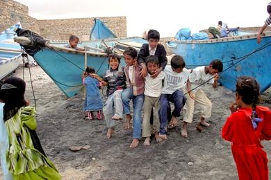 أطفال يمرحون قرب مرفأ لقوارب الصيد في قلنسية