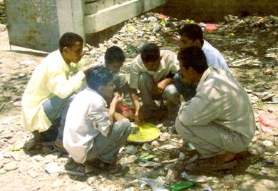 طلاب القسم يتناولون طعامهم في العراء والقمامة من تحتهم وتحيط بهم