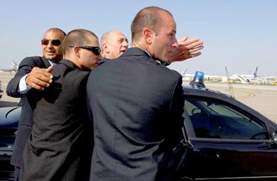 ضباط الأمن يدفعون برئيس الوزراء الإسرائيلي أولمرت إلى داخل السيارة بمطار بن جوريون أمس