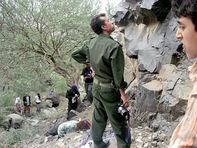 أفراد من الأمن يعاينون الموقع بعد العثور على جثة القتيلة في واد بجبل حبشي أمس