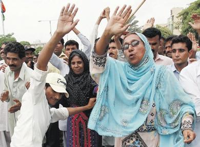 باكستانيون يرقصون خارج منزل الزعيمة الباكستانية المغتالة بنازير بوتو في كراتشي أمس احتفالا باستقالة مشرف