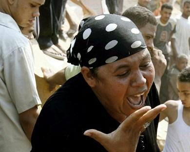 امرأة تبكي في عزبة بخيت شرق القاهرة بعد الانهيار الصخري أمس