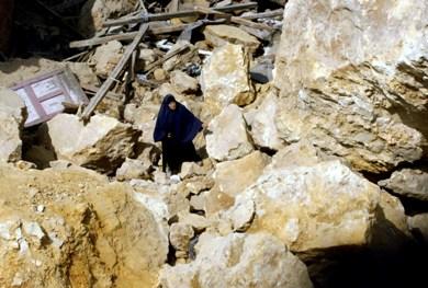 امرأة تبحث عن ما تبقى من منزلها بعد الانهيار الصخري