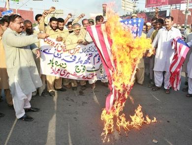 متظاهرون يحرقون العلم الامريكي احتجاجا على الضربة الجوية