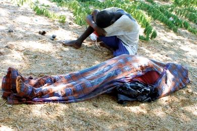 الشاب الأثيوبي أحمد جعفر يبكي بجانب جثة عمه حسين محمد بعد وصولهما أمس إلى  شاطئ قرية حصن بلعيد بأبين