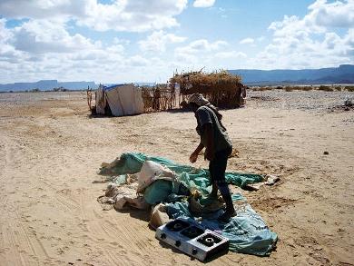مواطن يشير إلى بقايا خيمة في صحراء شبوة