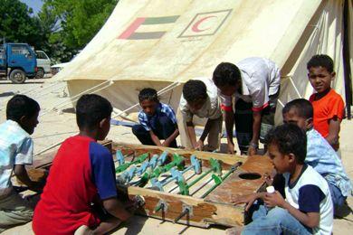 أطفال من الأسر المنكوبة بالجحيل يلعبون تحت المخيم بعيدا عن منازلهم