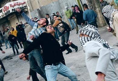 فلسطينيون يرمون الحجارة باتجاه جنود إسرائيليين خلال مواجهات في الخليل أمس