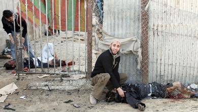 فلسطينيان يحاولان إنقاذ فتاة (يسار) ورجل (يمين) مصابين بجروح بالغة