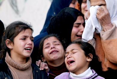 قريبات من أسرة الديب الفلسطينية يبكين أمس أثناء تشييع شهداء عشرة من أسرتهن استشهدوا في الغارة على مدرسة الأمم المتحدة