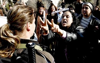 امرأة فلسطينية تصرخ بغضب مشيرة بعلامة النصر في وجه جندية إسرائيلية أثناء تظاهرة للتنديد بالعدوان الإسرائيلي على غزة بالقرب من بوابة دمشق في القدس القديمة أمس