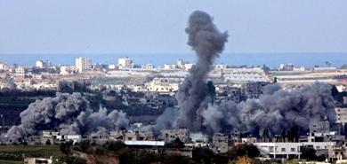 أعمدة الدخان تتصاعد بعد غارة جوية إسرائيلية كما بدت من المنطقة الحدودية بين غزة وإسرائيل أمس