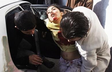 فلسطينيون يحملون فتاة أصيبت إصابة خطيرة إثر قصف إسرائيلي على بيت لاهيا شمال القطاع أمس