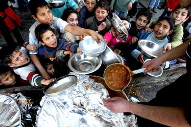 أطفال فلسطينيون لجأوا إلى مدرسة في مخيم جباليا يتسابقون للحصول على الغذاء أمس