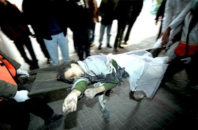 فلسطينيون يحملون جثة امرأة الى مستشفى الشفاء بمدينة غزة بعد استشهادها في غارة جوية إسرائيلية أمس