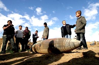 فلسطينيون يلقون نظرة أمس على قنبلة لم تنفجر ألقيت من طائرة تابعة لسلاح الجو الإسرائيلي في مدينة رفح على الحدود المصرية