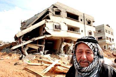 شيخ فلسطيني يمر من أمام ركام أحد المنازل