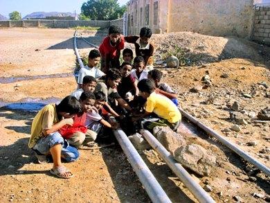 أطفال يحاولون أن يسدوا أنبوب مياه