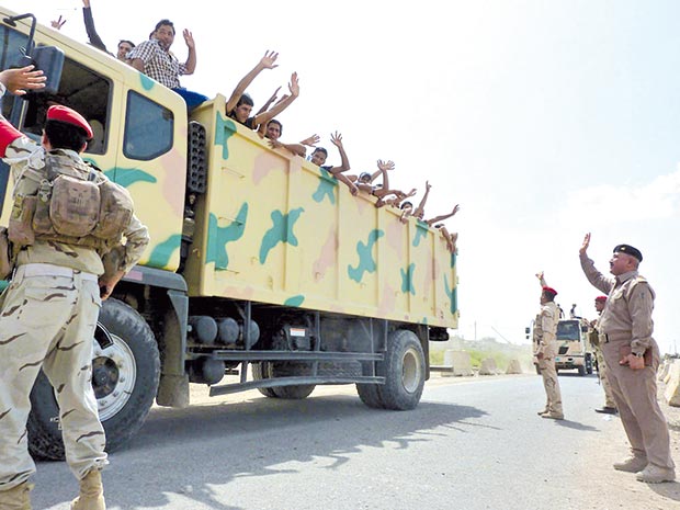 متطوعون عراقيون يتم نقلهم بواسطة الجيش إلى قاعدة المثنى وسط بغداد أمس