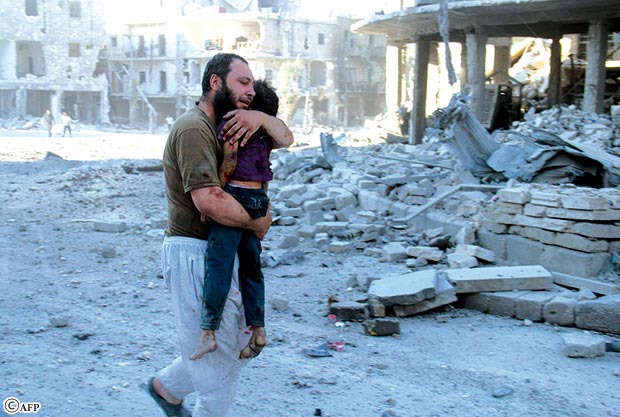 سوري يحمل جثة طفل في شوارع حلب بعد غارة جوية للقوات الحكومية أمس