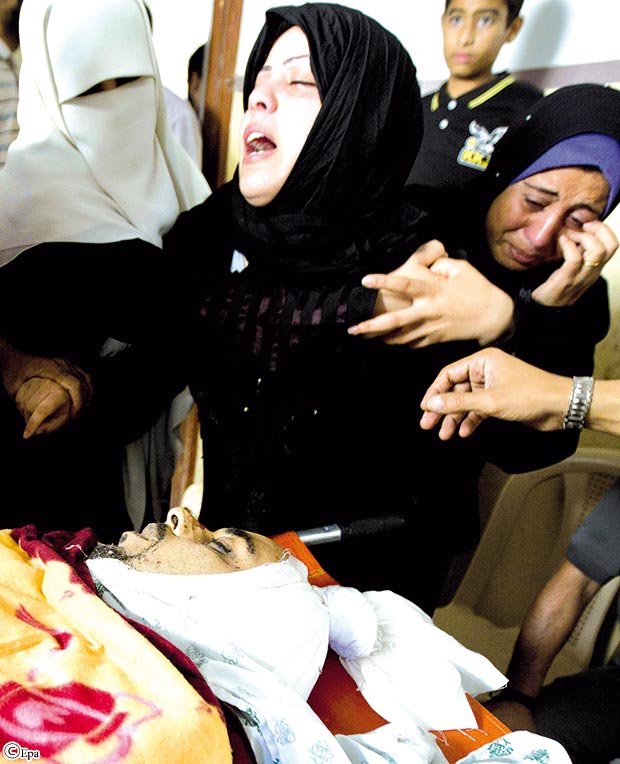 زوجة الطبيب
الفلسطيني أنس أبو
الكأس ( 33 عاما)
تبكي فوق جثته أثناء
الجنازة في بيت العائلة
بمخيم جباليا أمس