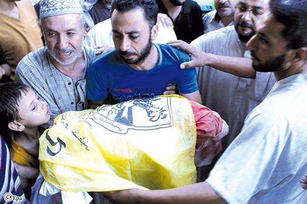 والد الطفل ساهر أبو نموس (3 سنوات) يحمل جثة ابنه في جنازته يوم أمس