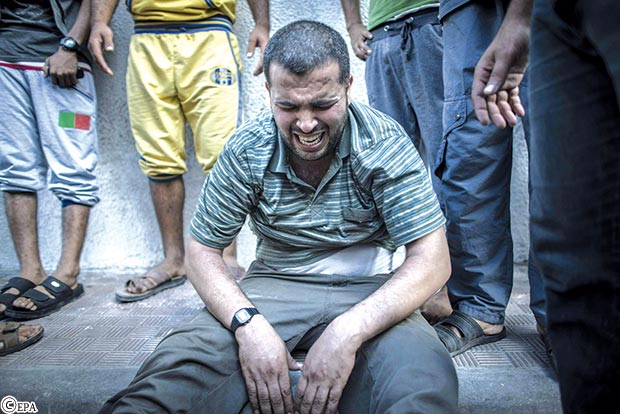فلسطيني يبكي بعد أن رأى جثتي ابنيه في مشرحة مستشفى الشفا يوم أمس الأول