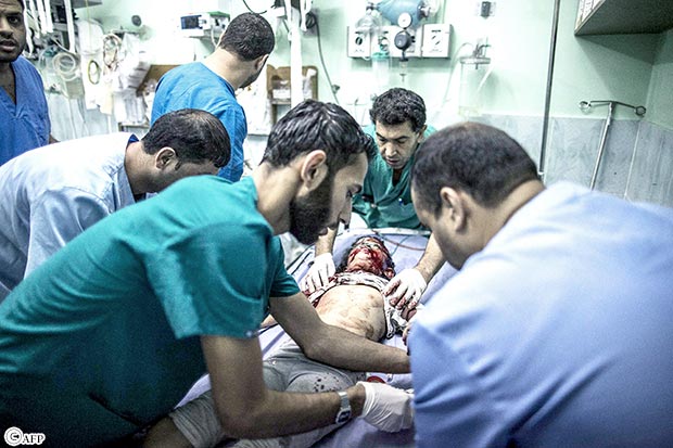 مسعفون يحاولون انقاذ الطفلة شهد قشطة بعد اصابتها بإصابة بليغة أمس