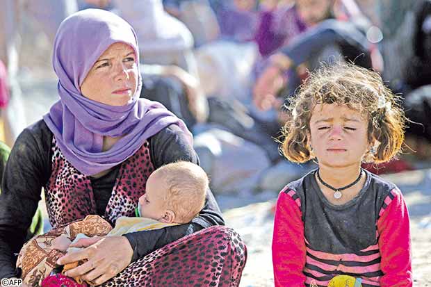 امرأة يزيدية وأطفالها بمعسكر باجد قندالا أمس