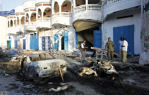 جنود ومدنيون يتفحصون بقايا الانفجار خارج مطعم ارومو أمس