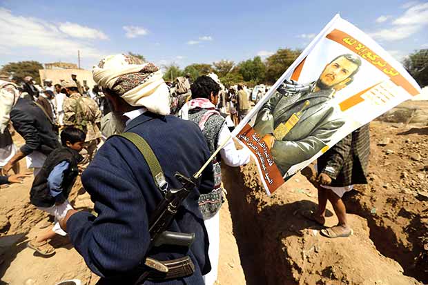 مسلح حوثي يرفع صورة لزعيم الجماعة في الحديدة أمس