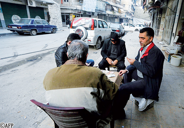 سوريون يلعبون الورق على الجانب التي تسيطر عليه الحكومة في حلب 