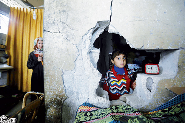 طفلة فلسطينية وأمها في منزلهما في غزة بينما تضرب عاصفة المنطفة منذ الإثنين الماضي