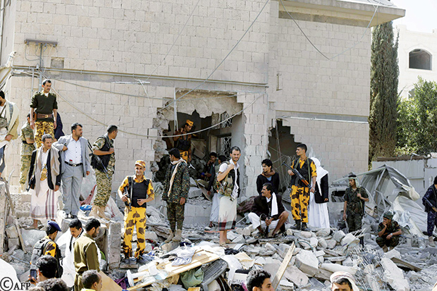 جنود من الأمن ووراءهم الحفرة التي خلفها التفجير