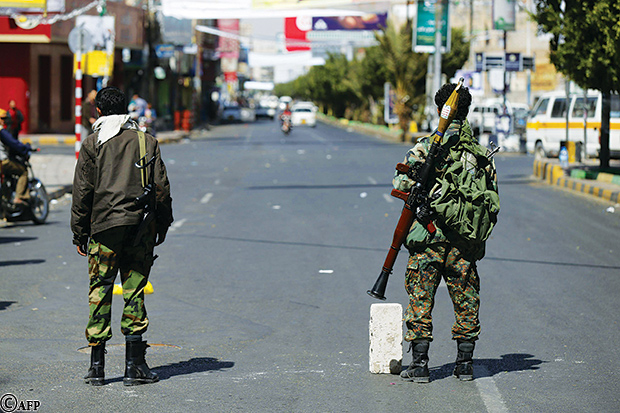 حوثيان مسلحان يلبسان زيا عسكريا في نقطة على أحد شوارع صنعاء