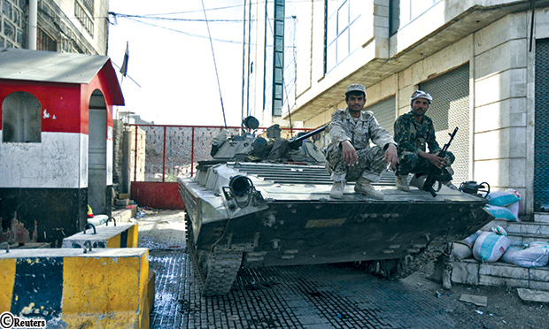 حوثيون بالزي العسكري فوق مدرعة خارج منزل الرئيس هادي بعد أن استولوا عليها في الاشتباكات الأخيرة