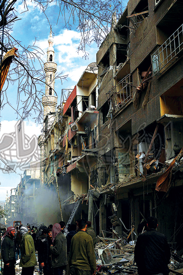 سوريون خارج مبنى مهدم يبحثون عن أحياء بعد ضربة جوية في منطقة دوما شرق دمشق أمس