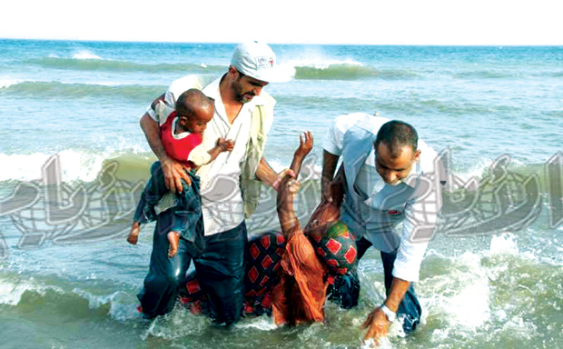 ‎مهاجرون أفارقة خلال عملية إنقاذ في الشاطئ