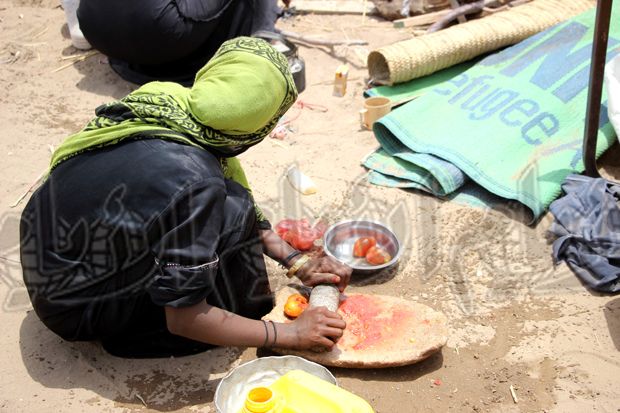 امراة من النازحات اثناء اعدادها للطعام