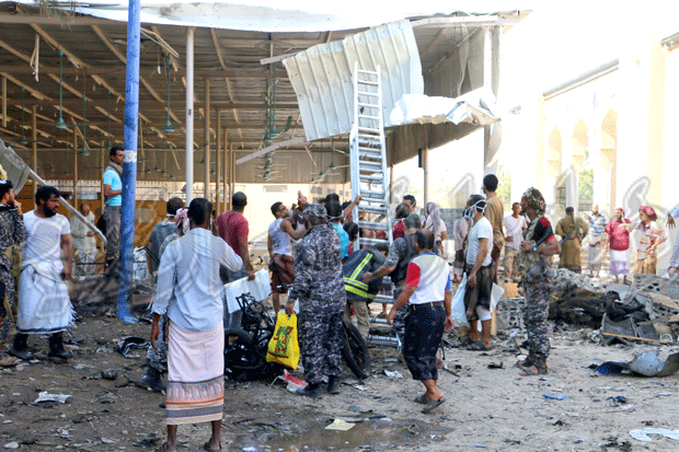 مسعفون أثناء محاولتهم انزال جثة دفعها الانفجار الى سطح سقيفة مسجد زايد