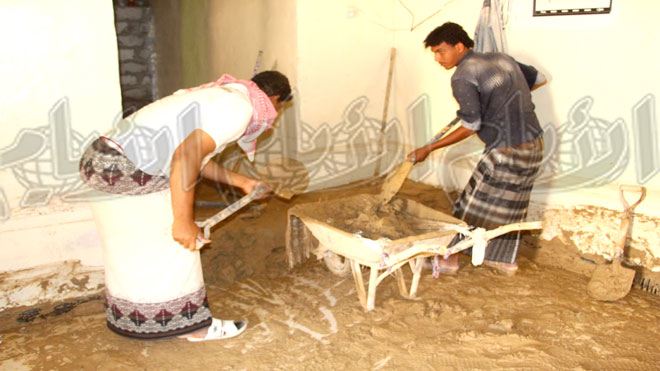 عملية اخراج الطين الذي جرفه الاعصار للمنزل