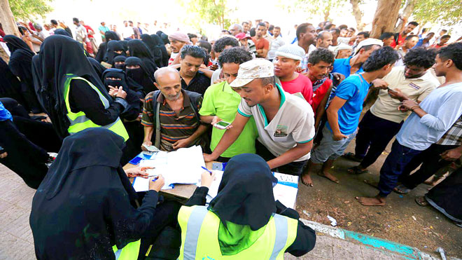 أشخاص يتجمعون عند مركز لتوزيع المساعدات تابع للأمم المتحدة في مدينة الحديدة 