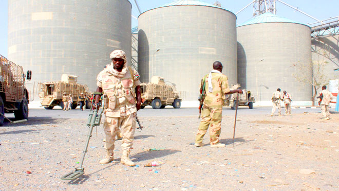 جنود سودانيون يمسحون بحثا عن ألغام داخل صوامع الغلال، أمس