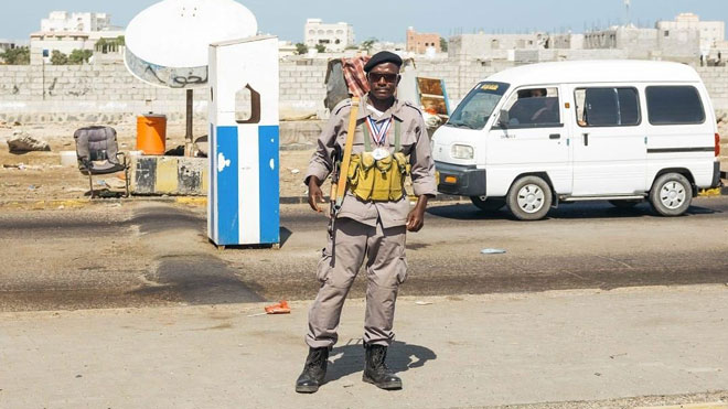 محمد شيخ القوايتي يقف على نقطة تفتيش في مديرية خورمكسر في عدن. 