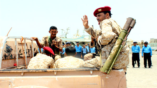 مقاتل من الحوثيين يتجول مع آخرين في ظهر شاحنة صغيرة أثناء الانسحاب من ميناء الصليف