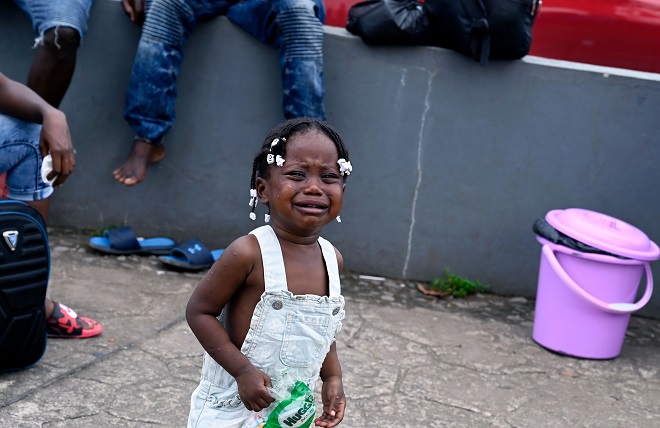 فتاة مهاجرة من هايتي تبكي خارج المعهد الوطني المكسيكي للهجرة في تاباتشولا