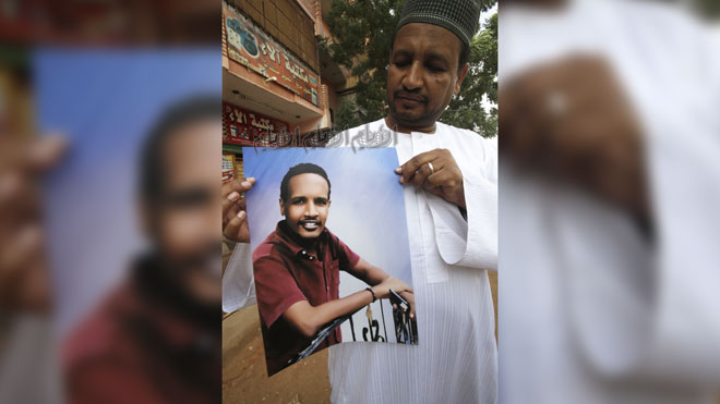 يحمل شقيق علي محمد الفاضل صورة أخيه الذي قتل في مظاهرة في الخرطوم